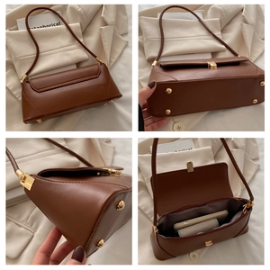 Detail view of brown vintage underarm bag showing metal clasp, bottom studs and interior