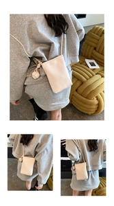 Detail of beige litchi grain phone crossbody bag with decorative side knot charm