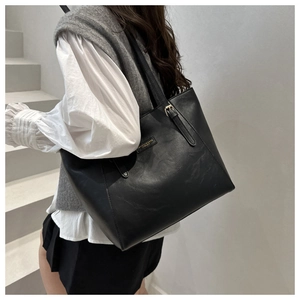 Detail of black matte leather tote bag with elegant gold hardware for office and daily wear