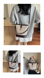 Detail of color-block bucket bag with canvas stitching, leather trim and gold buckle