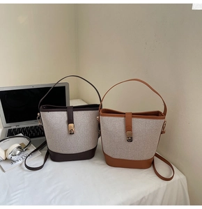 Detail of contrast-color canvas bucket bags with leather trim and vintage metal locks