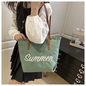 Detail of mint green canvas tote with Summer embroidery and fringe edge trim