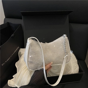 Sac baguette à paillettes blanches avec chaîne argentée sur une boîte cadeau de luxe noire