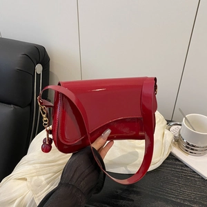 Red patent leather shoulder bag with cherry charm and asymmetric curved flap design