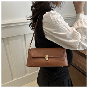 Detail of a brown vintage baguette bag featuring smooth leather and gold buckle clasp