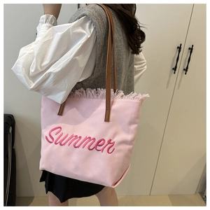 Close-up of pink canvas tote bag with Summer embroidery and stylish fringe edge detailing