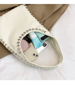 Detail of off-white rivet tote showing spacious interior with phone and cosmetics