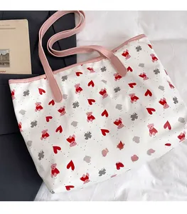 Close-up of bear and floral print on white canvas tote bag with pink leather handle