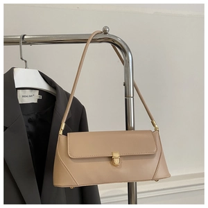 Detail of beige baguette bag with gold buckle styled on a grey blazer and metal hanger