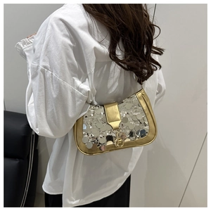 Close-up of silver sequins and golden metal trim on a stylish lady's shoulder bag