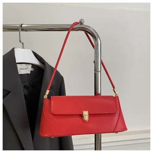 Detail of red leather baguette bag with gold metal buckle and bottom protective studs