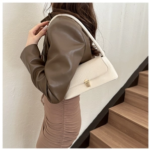 Detail of white crocodile pattern shoulder bag with a square golden metal buckle lock