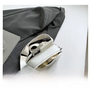 Vue détaillée de l'intérieur d'un sac bandoulière blanc montrant l'espace de rangement