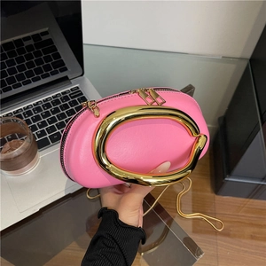 Chic pink oval crossbody bag with large gold handle ring and slim chain strap