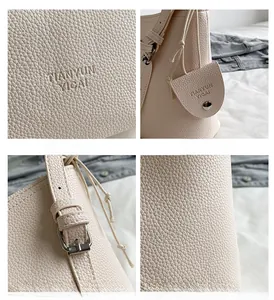 Detail of off-white lychee grain leather handbag with adjustable strap and embossed logo