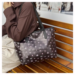 Sac fourre-tout à fleurs porté par un mannequin avec motifs de fleurs et de nœuds