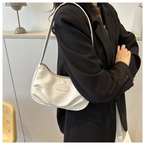 Dettaglio della borsa a spalla bianca a mezzaluna con pieghe e logo in metallo su pelle