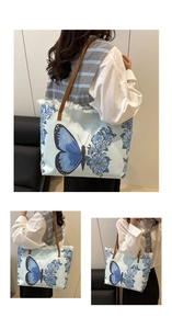 Détail du sac seau en toile avec imprimé papillon bleu, bords effilochés et bandoulière en cuir