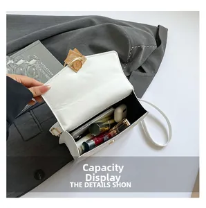 Detailed view showing large capacity for smartphone and cosmetics in white flap bag