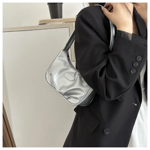 Close-up of the silver metallic crescent bag featuring pleated texture and brand logo