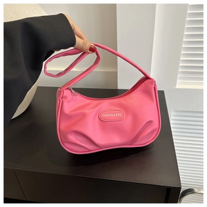 Detail of rose pink pleated PU shoulder bag with metal fashion logo plaque and zipper