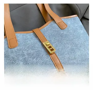Macro shot of gold twist lock on blue denim fabric with brown leather strap detail