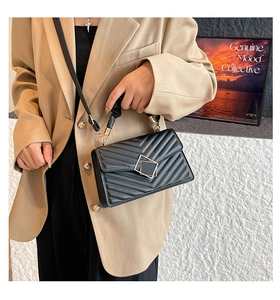 Detail of black chevron quilted crossbody bag featuring unique double square metal buckle