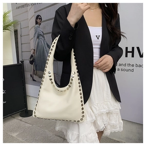 Close-up of beige hobo bag with silver stud trim and sleek leather finish
