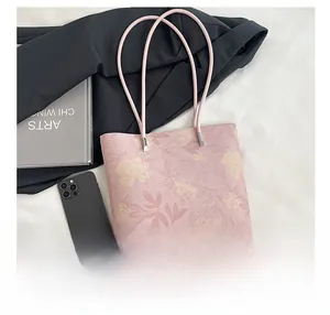 Detail of pink floral tote bag with silver hardware on elegant lifestyle background