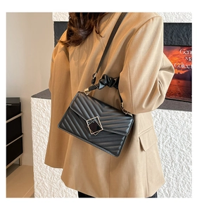 Detail of black chevron quilted crossbody bag with gold hardware and ruched handle