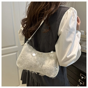 Detail shot of silver sequin shoulder bag showing shimmering texture and white strap