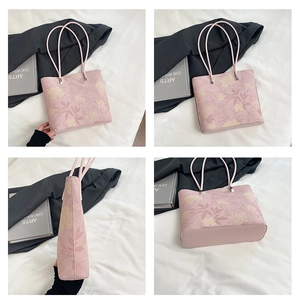 Detail view of pink floral print tote bag with elegant botanical patterns and slim handles