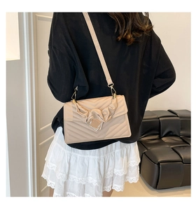 Detail of apricot quilted shoulder bag with V-stitch texture and elegant metal clasp