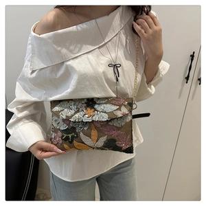 Detailed embroidery view of floral sequins on elegant envelope crossbody bag