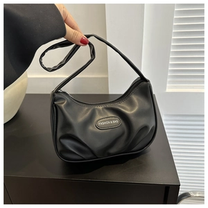 Close-up of black crescent underarm bag with polished PU leather and fashion plaque