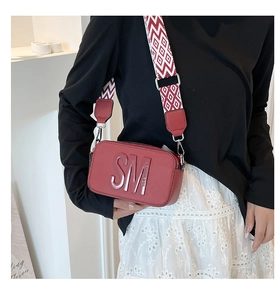 Détail du sac à bandoulière rouge avec logo Steve Madden et sangle tissée géométrique