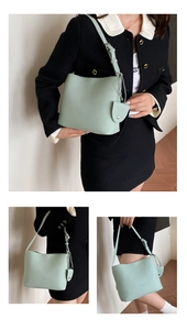 Detail view of mint green lychee grain leather bucket bag with adjustable strap