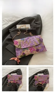 Dettaglio ricamo floreale con paillettes su tessuto beige con catena dorata elegante