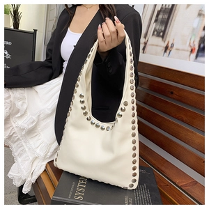 Detail of silver rivets on cream hobo shoulder bag with smooth faux leather texture