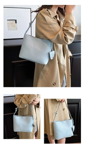 Detail of light blue lychee pattern tote bag with heart charm and brand logo embossed