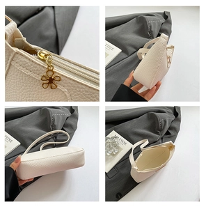 Detail of white lychee texture handbag with a unique gold flower-shaped metal zipper pull