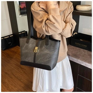Detail of vintage tote bag with contrast stitching and golden rectangular metal buckle