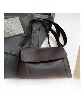Detailed view of dark brown PU leather tote bag with flap closure on a white surface
