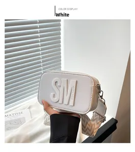 Vue détaillée d'un sac bandoulière rectangulaire blanc avec finition texturée et sangle tissée