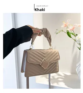 Detail of khaki quilted PU leather handbag featuring a ruched handle and metal buckle