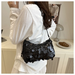 Detail of a chic black sequined shoulder bag styled on a person for a party look