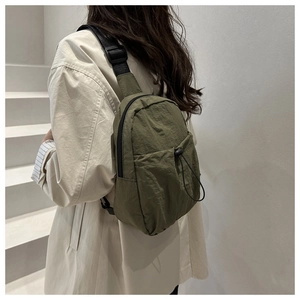 Macro detail of army green nylon crossbody bag showing the adjustable strap and drawstring pocket