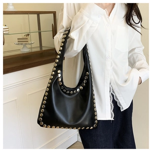 Detail shot of black leather hobo bag with large silver studs on shoulder strap