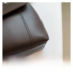 Detail of premium chocolate brown faux leather texture and sturdy reinforced stitching