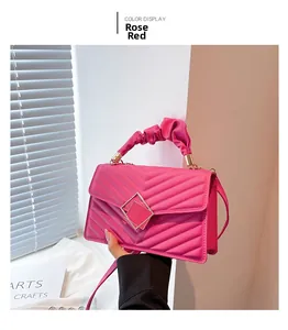 Detail of rose red rhombic quilted crossbody bag with pleated handle and square buckle